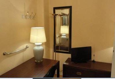 Dunkle Holzmöbel mit einem kleinen Fernseher und einer Tischlampe darauf