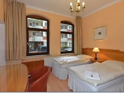 Zweibettzimmer mit Arbeitsplatz und zwei großen Fenstern