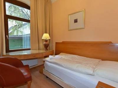 Einzelzimmer mit Sitzbereich und rotem Lederstuhl