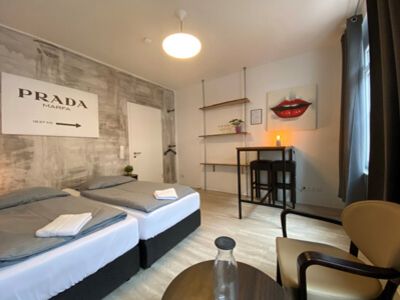 Doppelzimmer in einem Hotel mit Laminatboden und Wand in Betonoptik mit