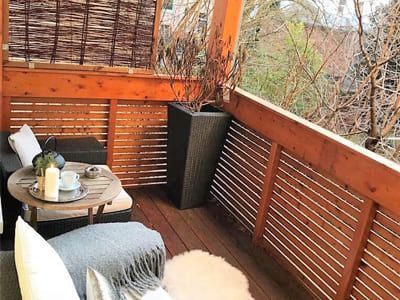 Holzbalkon mit Gartenmöbeln und Deko