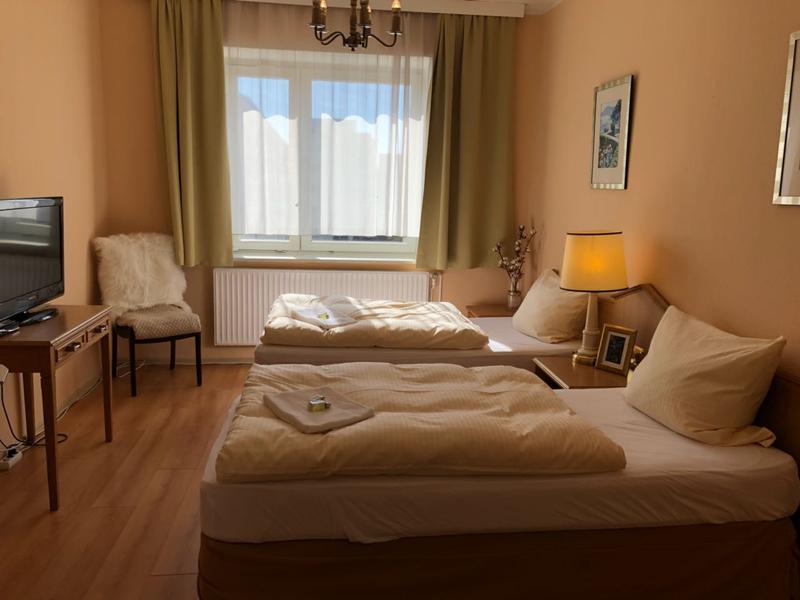 Zweibettzimmer mit einem Fernseher und einem Stuhl in der Ecke