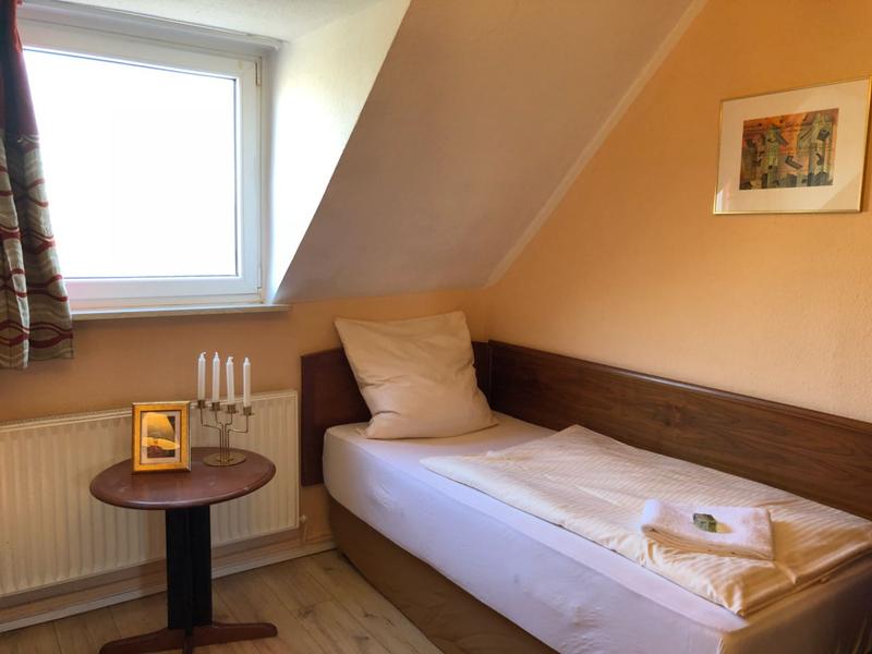 Einzelbett unter einer Dachschräge mit Beistelltisch