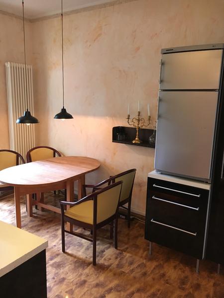 Essbereich mit zwei schwarzen Hängelampen neben der Küchenzeile