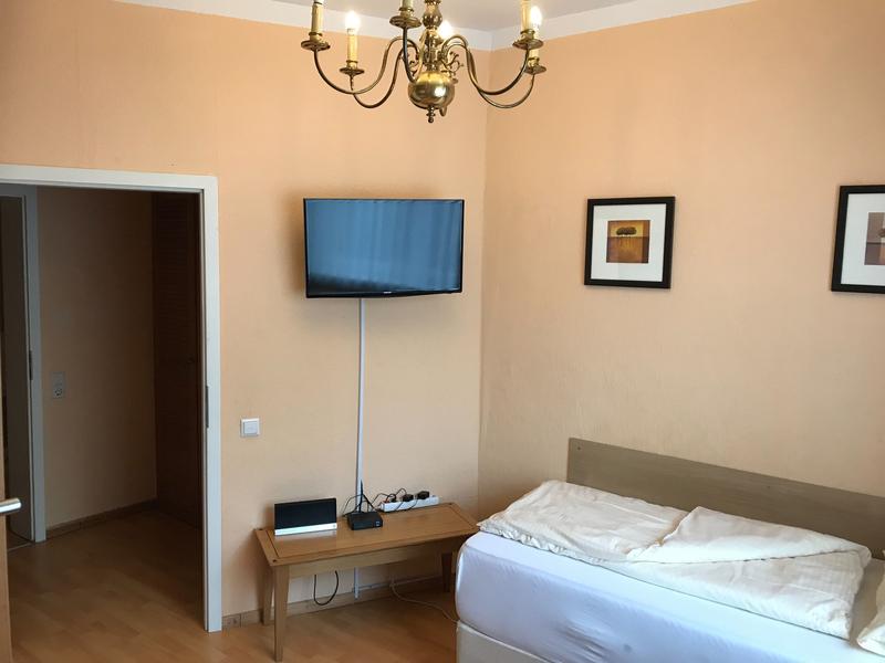 Schlafzimmer mit Fernseher und geöffneter Tür