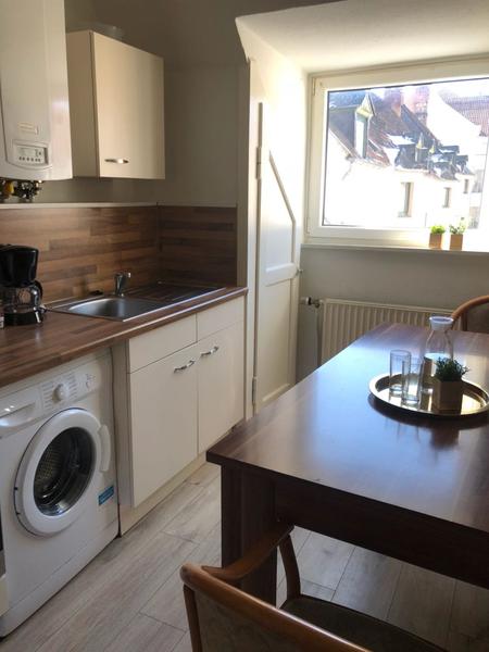 Kleine helle Küchenzeile mit Waschmaschine und Sitzplatz