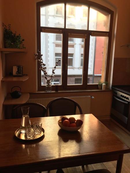 Essbereich in der Küche mit Holzmöbeln und Rundbogenfenster