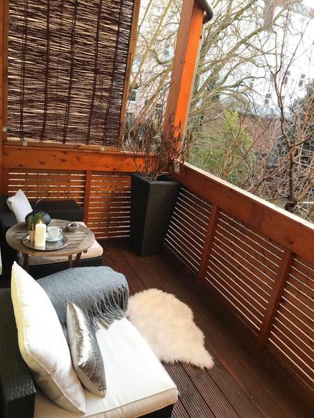 Gemütlich ausgestatteter Balkon mit Sitzmöbeln und Beistelltisch