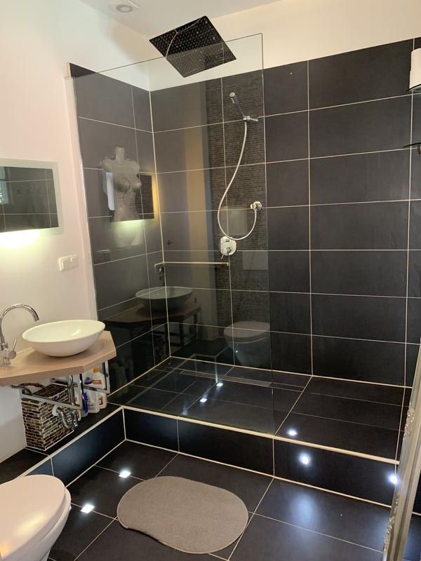 Modernes Bad mit großer Dusche und dunklen Fliesen