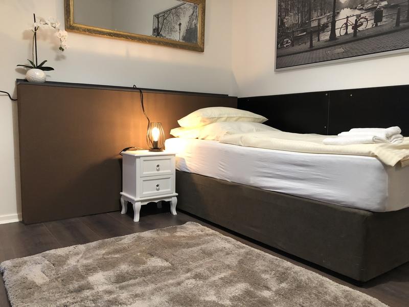 Schlafzimmer mit dunklem Boden und halbhoher Wandverkleidung