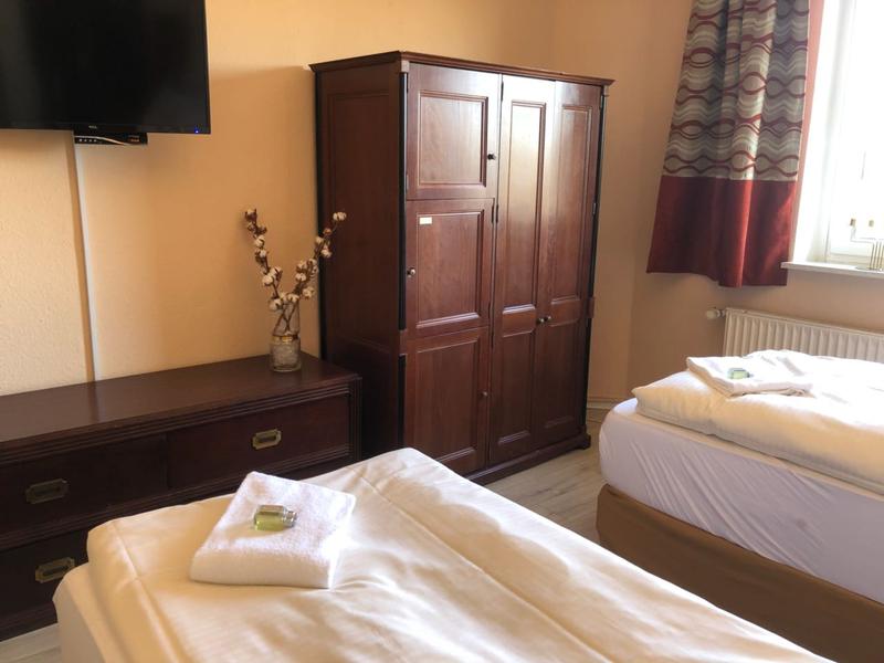 Dunkle Holzmöbel in einem Zweibettzimmer