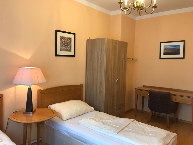 Zweibettzimmer mit Schrank und Schreibtisch