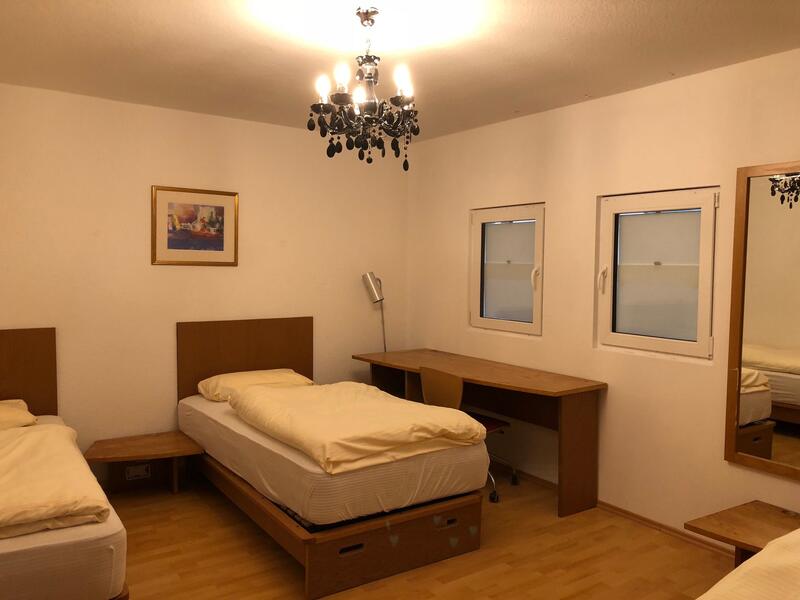 Pokój wieloosobowy z biurkiem i żyrandolem