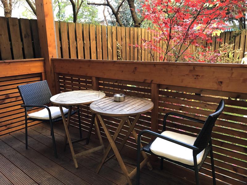 Balkon mit Sitzmöbeln und Tischen aus Holz