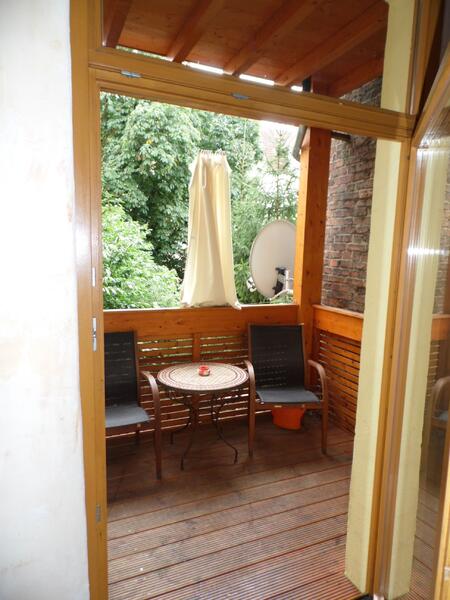 Überdachter Balkonbereich mit zwei Stühlen und Beistelltisch