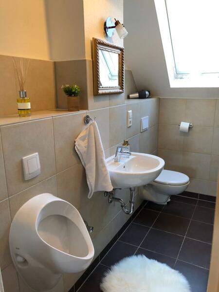 Helle Bad mit Dachschräge und dunklem Fliesenboden