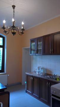 Küche in dunklem Holz mit Kronleuchter