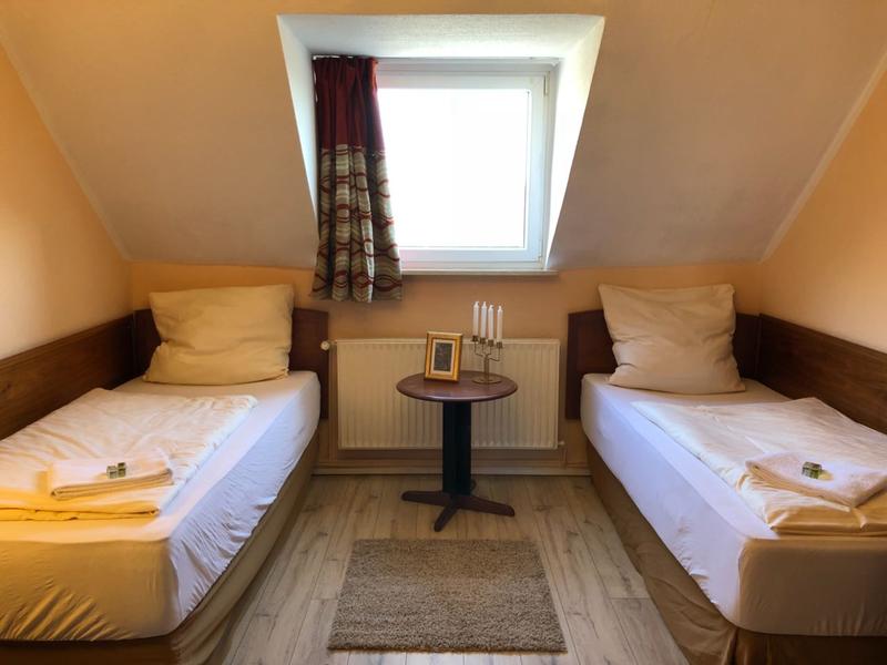 Zweibettzimmer mit Dachschräge und Beistelltisch