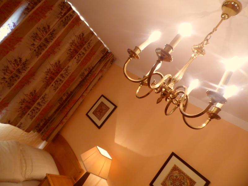 Schlafzimmer mit gemusterten Vorhängen und Kronleuchter